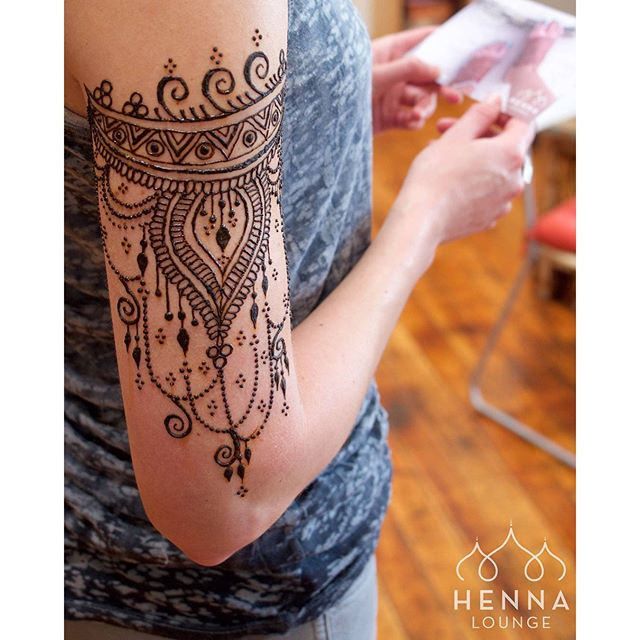 a woman with a henna tattoo on her arm