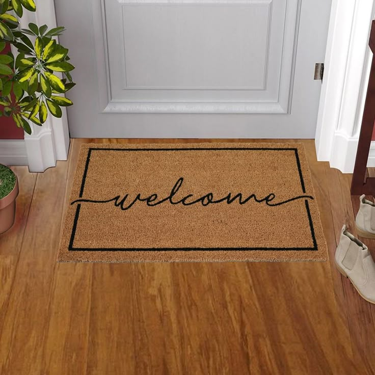 Welcome guests with a simple style, "Welcome" printed coir doormat. Coir fibers used to make this mat are extracted from Coconut husks, which are otherwise wasted. Each mat uses fiber from about 16 coconuts. The fiber is converted to yarn and then used to make these versatile doormats. After making the plain mat, the design is hand-stenciled by craftsmen, one layer at a time. The naturally resilient Coir mat scrapes mud, sand, water and dirt off shoes and the vinyl backing is slip resistant and durable. This is a highly functional doormat. Style Selections 1-1/2-ft x 2-1/2-ft Natural Coir/Vinyl Rectangular Indoor or Outdoor Decorative Door Mat in Black | WG-1830-CURSWEL Cute Door Mat, Last Name Door Mat, Hand Painted Door Mats, Front Door Mat Ideas, Front Door Matt, Fromt Doors, Door Mats Outdoor, Cute Door Mats, Doormat Ideas