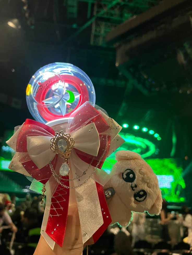 a person holding up a teddy bear in front of a stage