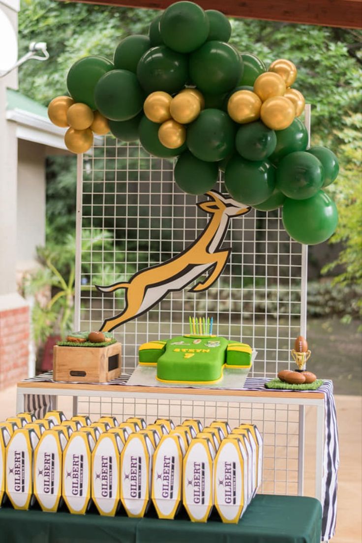 a table topped with green and gold balloons