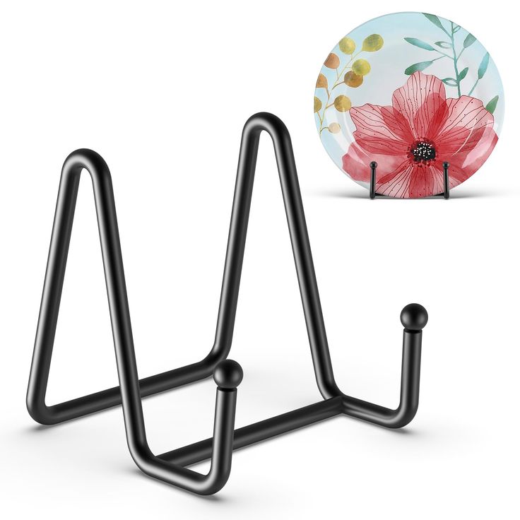 a pair of black metal hooks next to a plate with a flower design on it