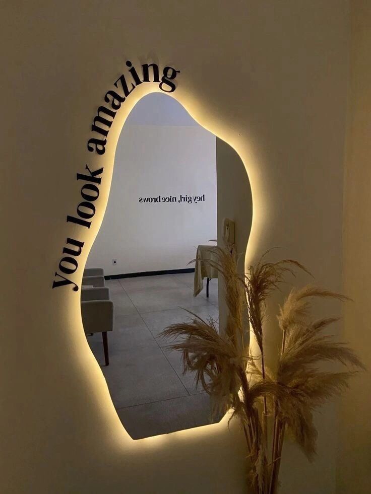 there is a mirror that has the words amazing looking on it and some plants in front of it