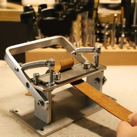 a person is holding a piece of wood in front of a metal device with corks on it