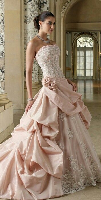 a woman in a pink wedding dress posing for the camera