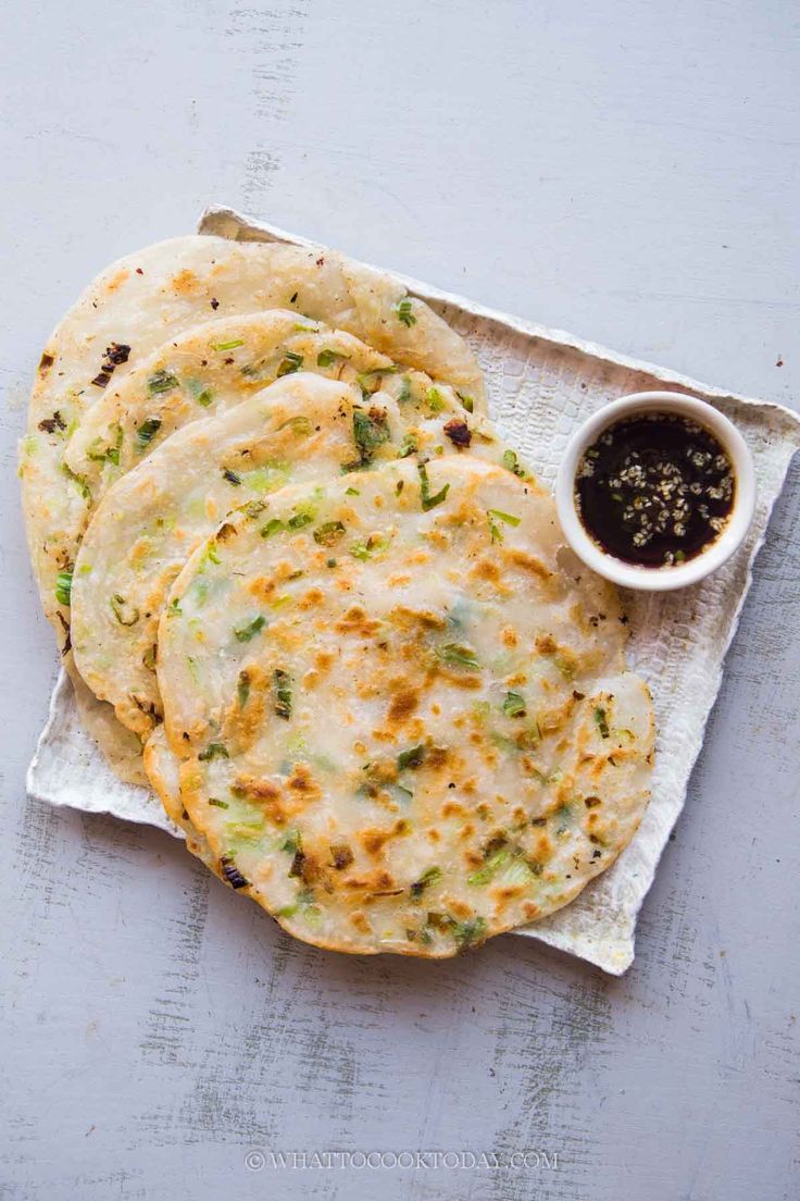 several flatbreads on a napkin with dipping sauce