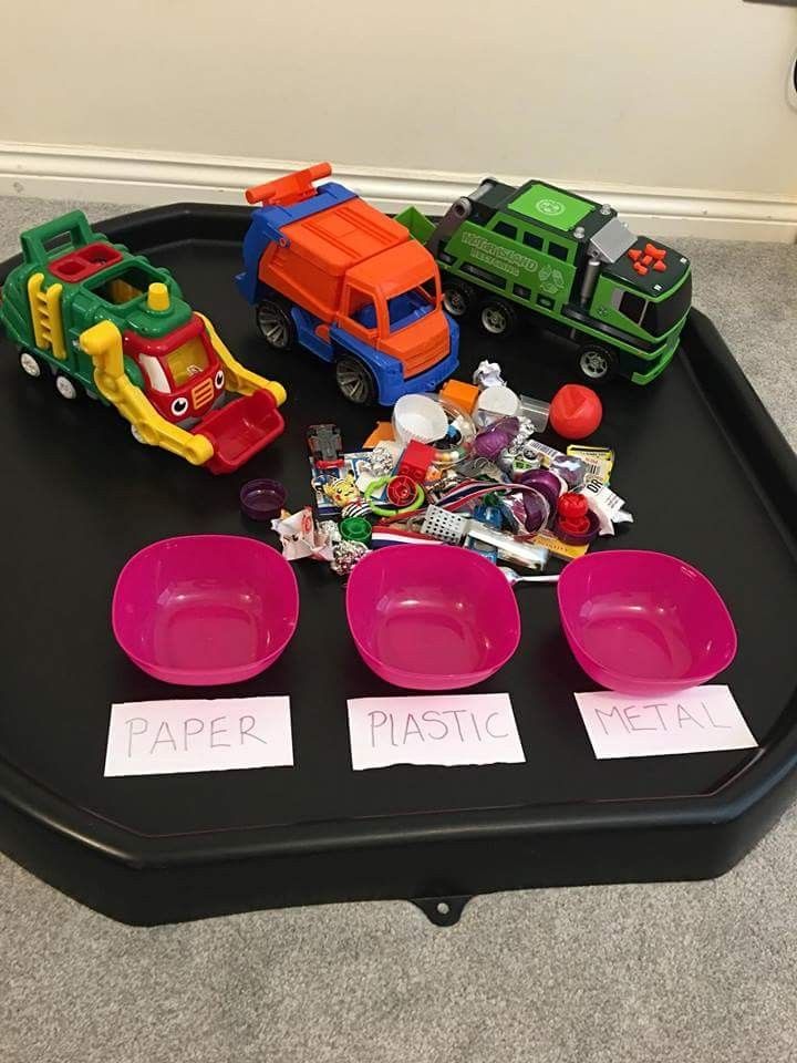 a black tray with pink plates and toy cars on it, labeled paper plastic real