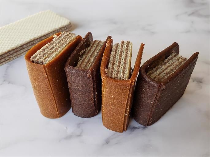 four pieces of cake sitting on top of a marble countertop next to each other