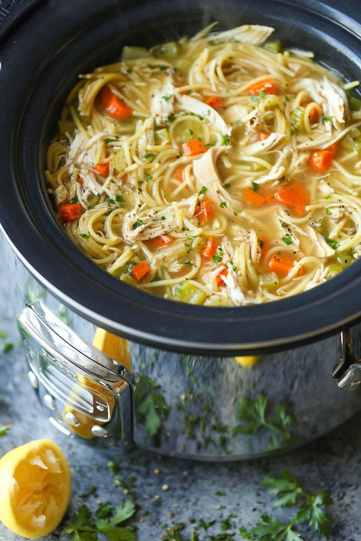 a pot filled with noodles and carrots on top of a table