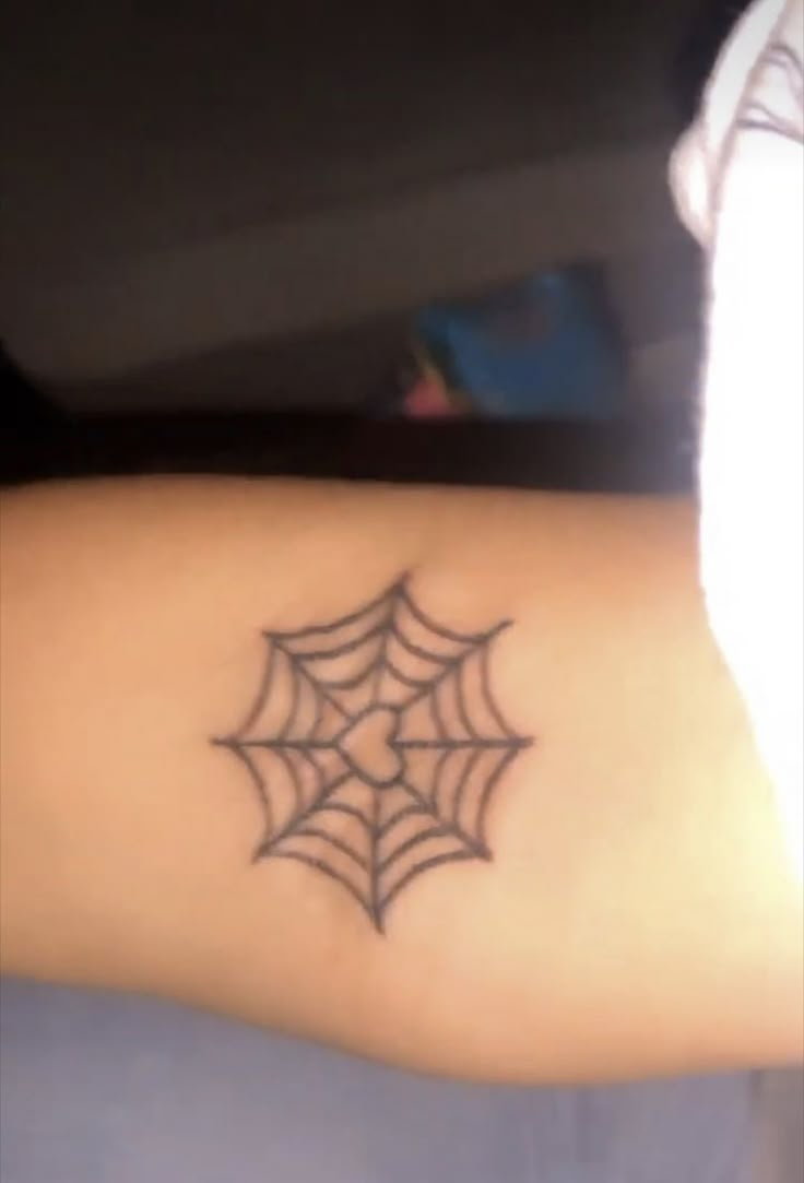 a person with a spider web tattoo on their arm