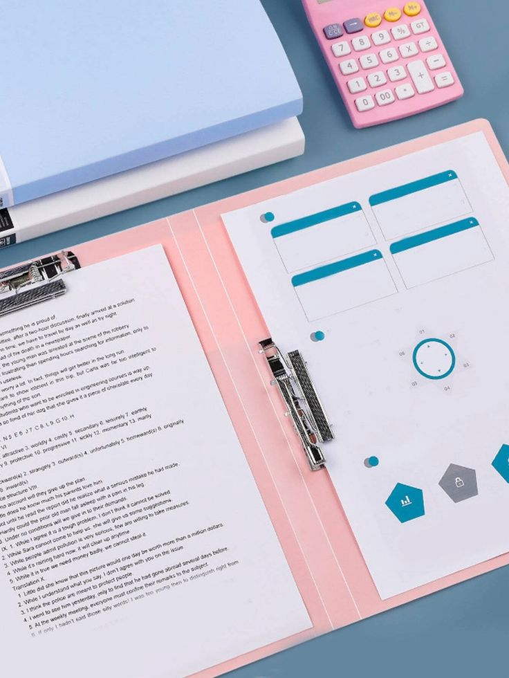 a binder, pen and calculator sitting on top of a pink folder