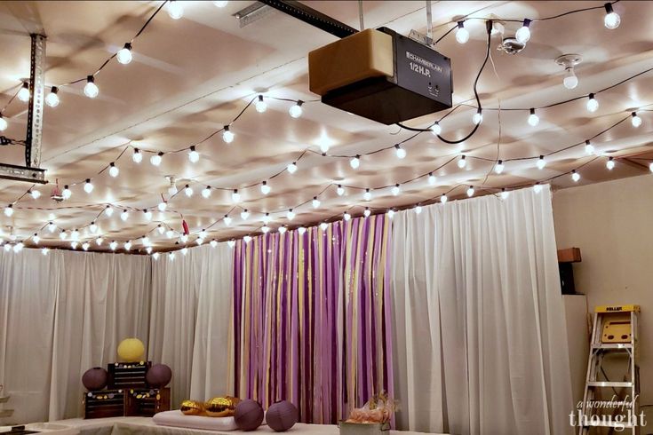 the ceiling is covered with lights and drapes in an empty room that has purple curtains