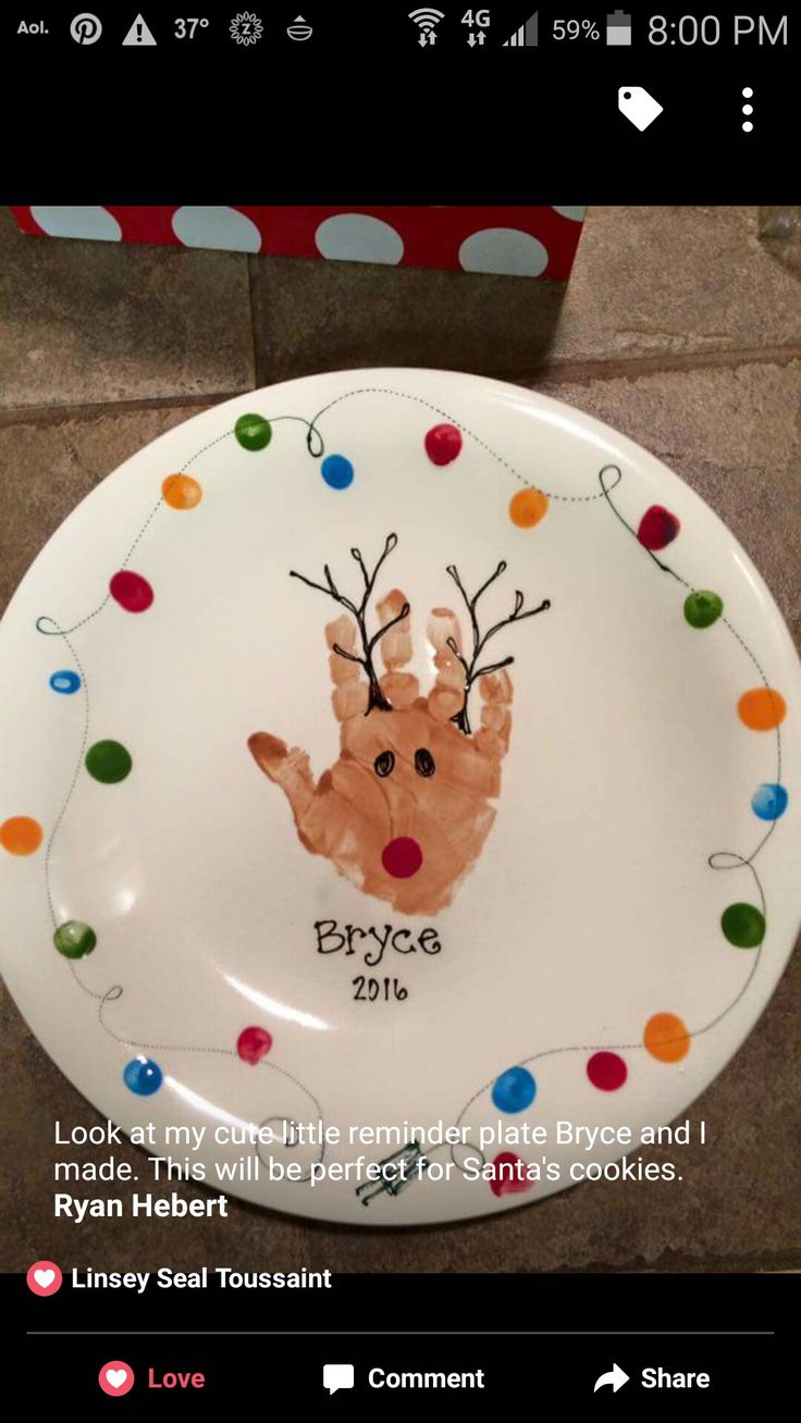 a white plate with a handprinted reindeer on it and colorful balls around the rim