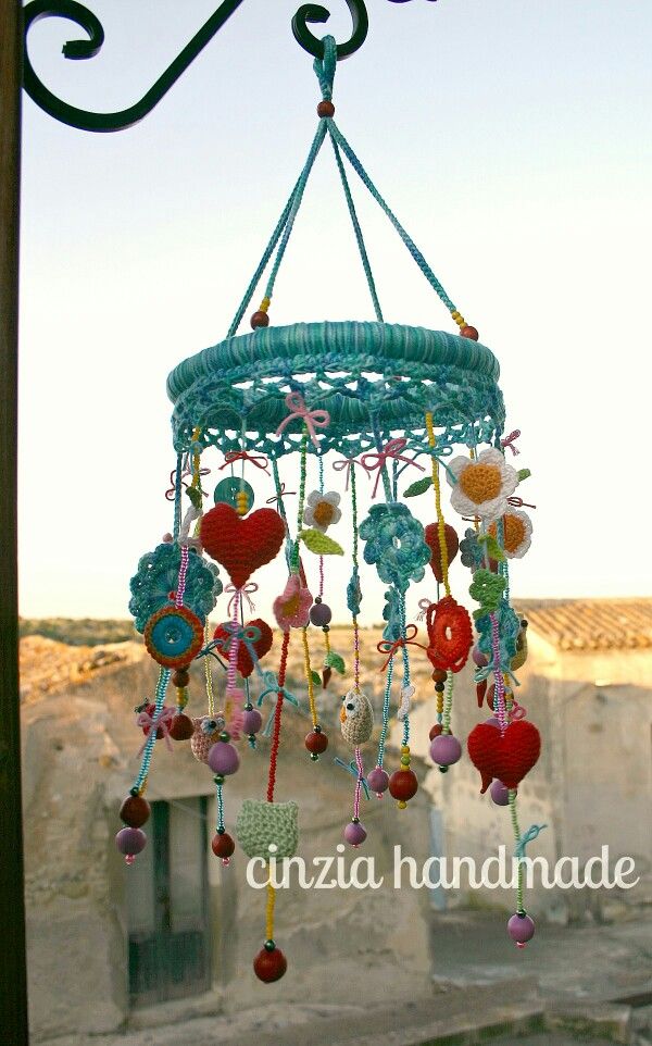 a wind chime hanging from the side of a building with lots of beads on it