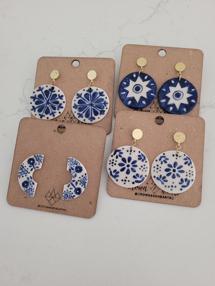 four pairs of blue and white ceramic earrings are displayed on a card with tags attached to them