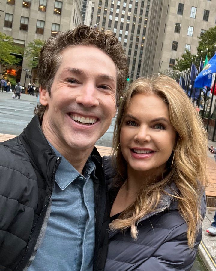 a man and woman standing next to each other in front of a cityscape