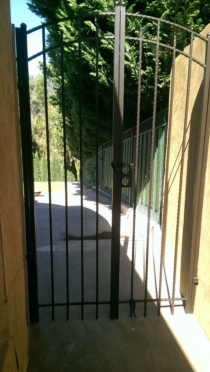 an open gate in front of some trees