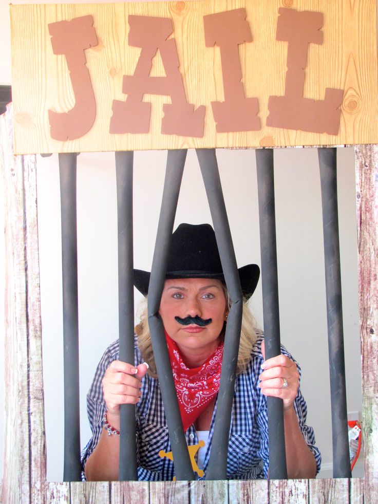 a woman behind bars with a fake moustache on her face and the word jail painted on it