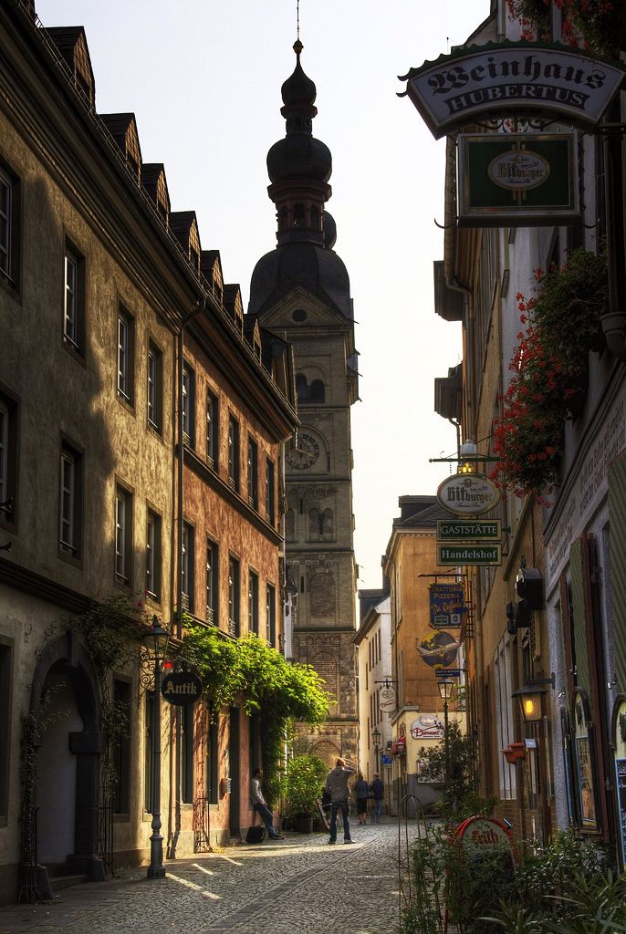 an alley way with buildings and people walking on the side walk in front of it