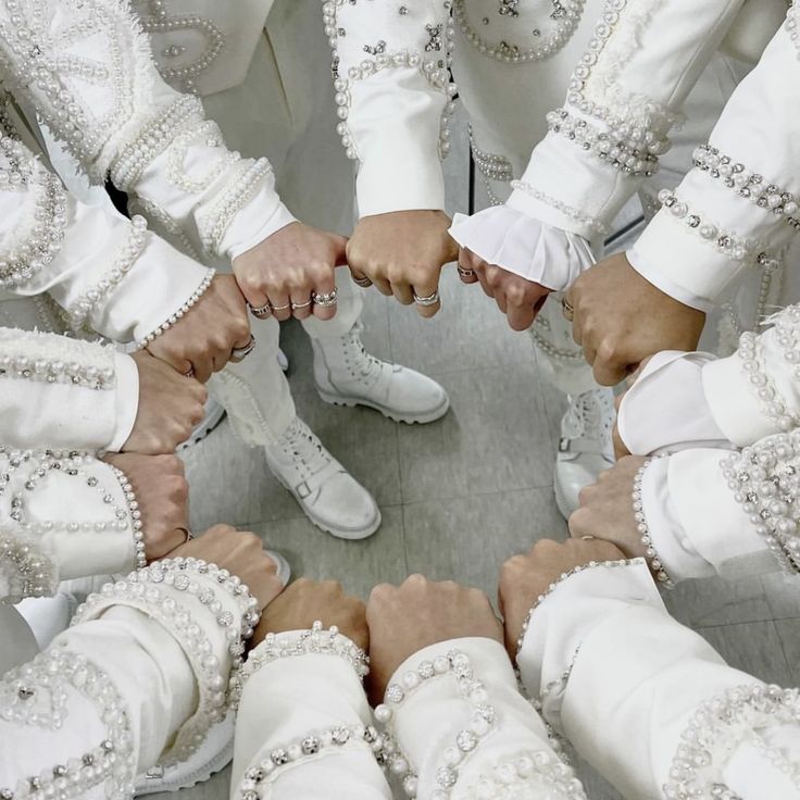 a group of people standing in a circle with their hands together