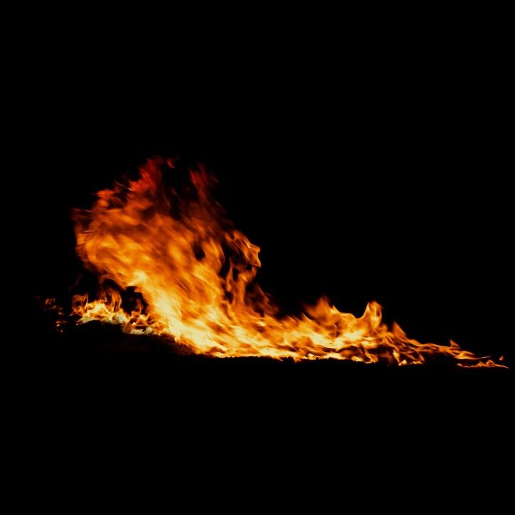 a large fire is burning in the dark