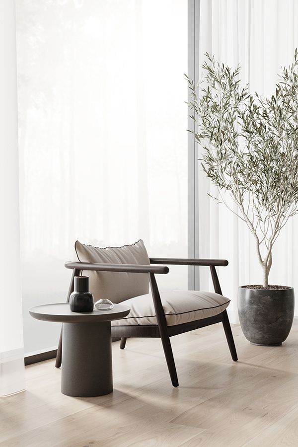 a living room with a chair, table and potted plant on the floor in front of a window