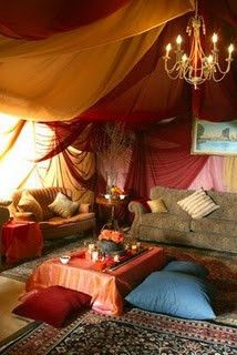 a living room filled with furniture and a chandelier hanging over the top of it