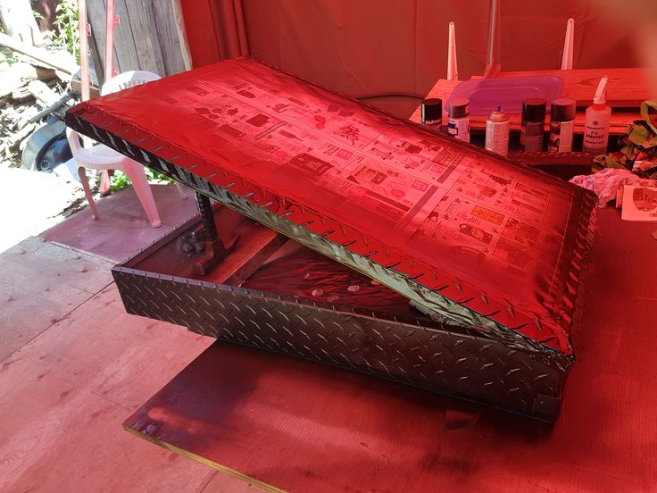 a large metal box sitting on top of a wooden floor next to a red wall