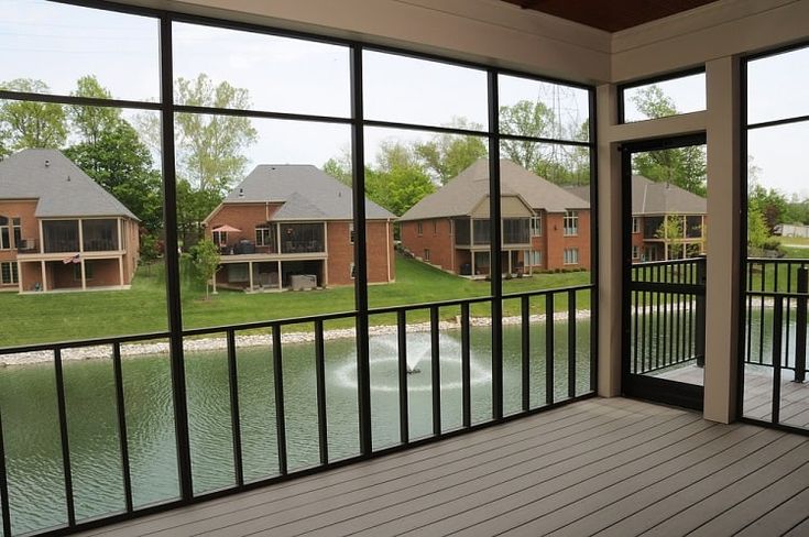 an open balcony with water and houses in the background