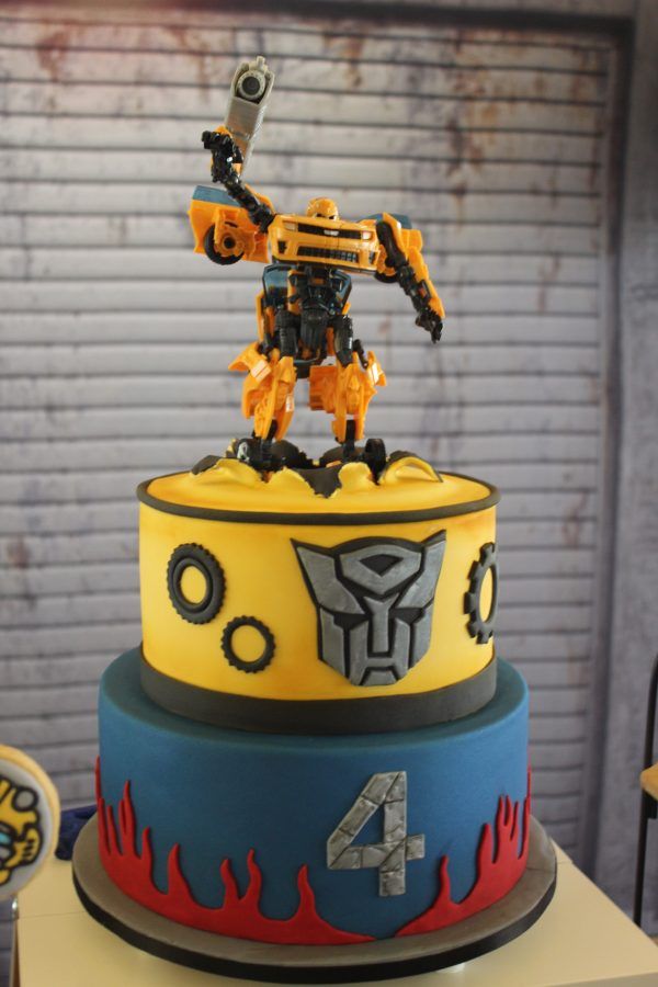 a birthday cake with an image of a robot on top and flames coming out of it