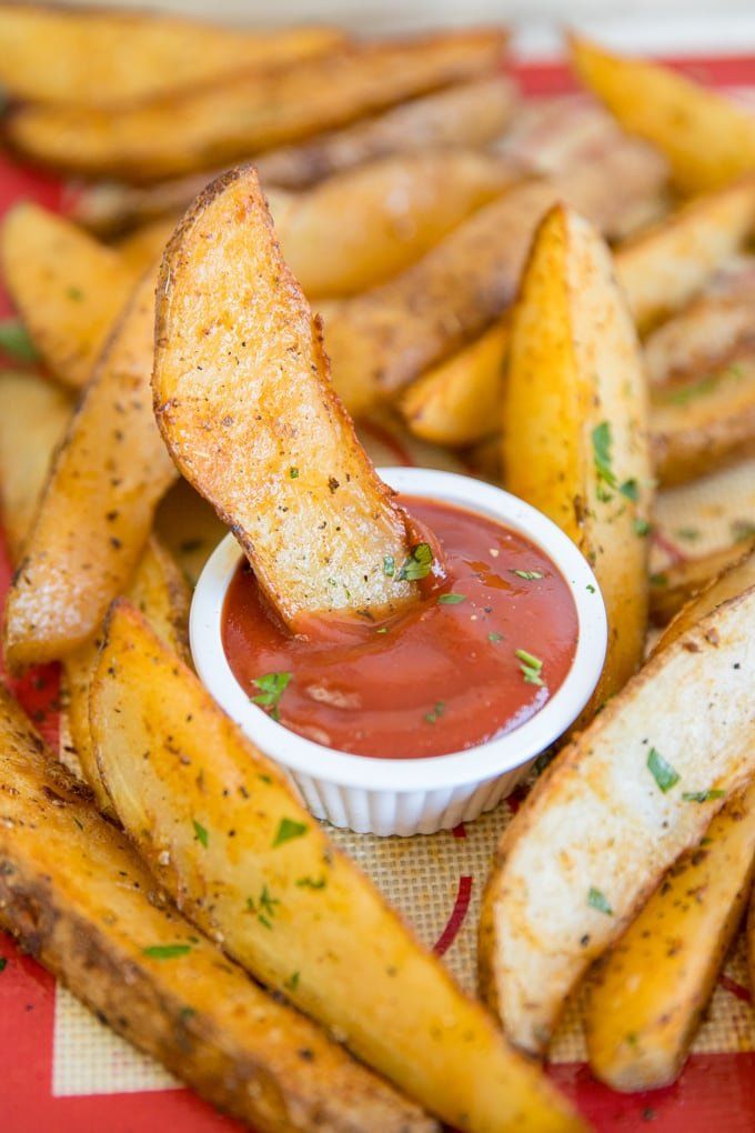 french fries with ketchup and parmesan on a red checkered tablecloth