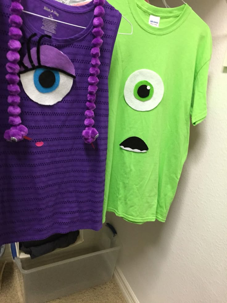 two t - shirts that look like monsters hanging on a clothes rack