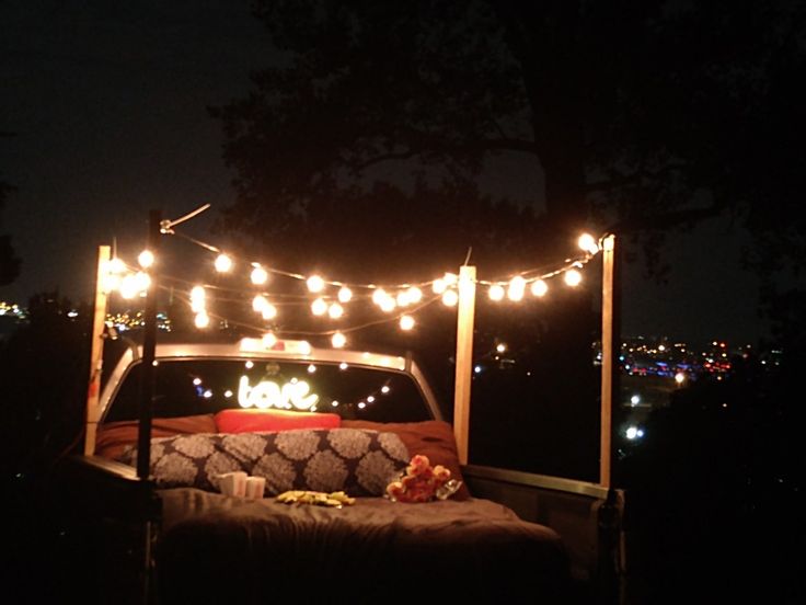 a bed with lights hanging from it's headboard in the back of a truck