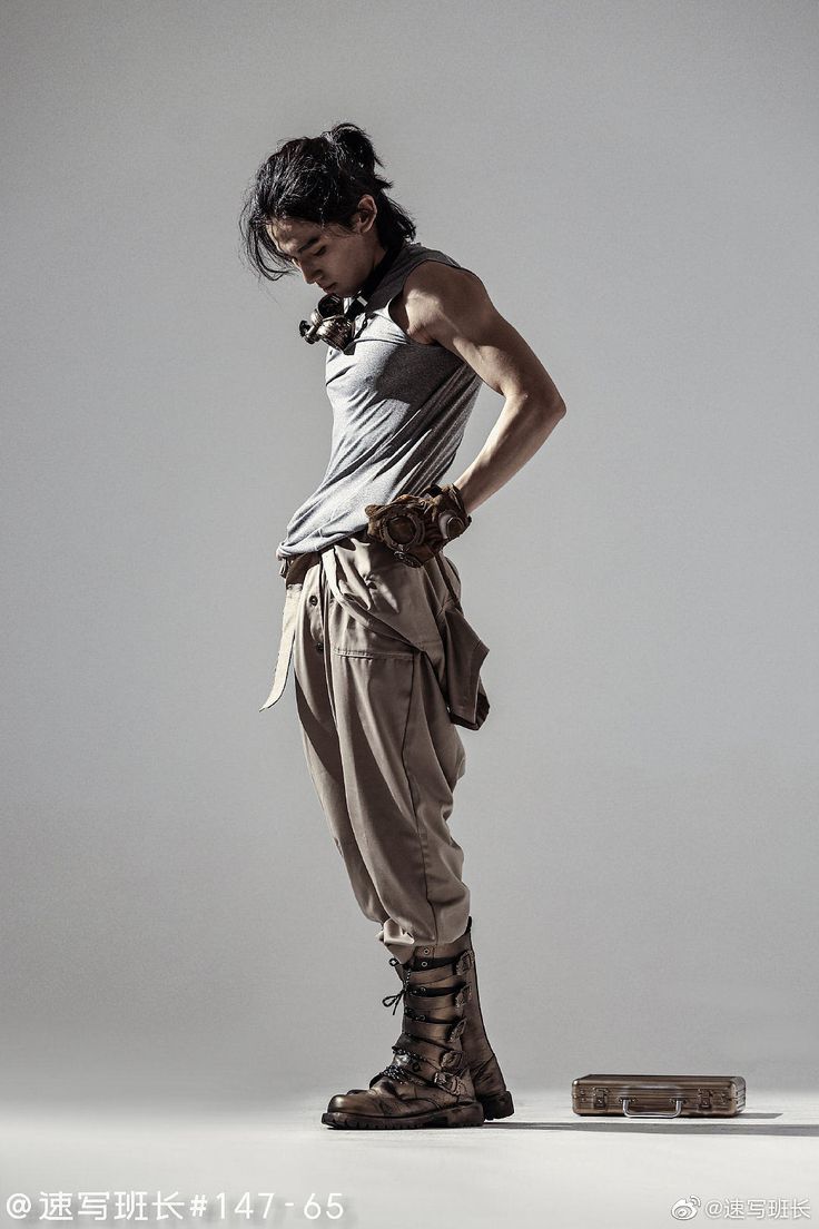 a man with his hands on his hips standing in front of a white background wearing gladia sandals