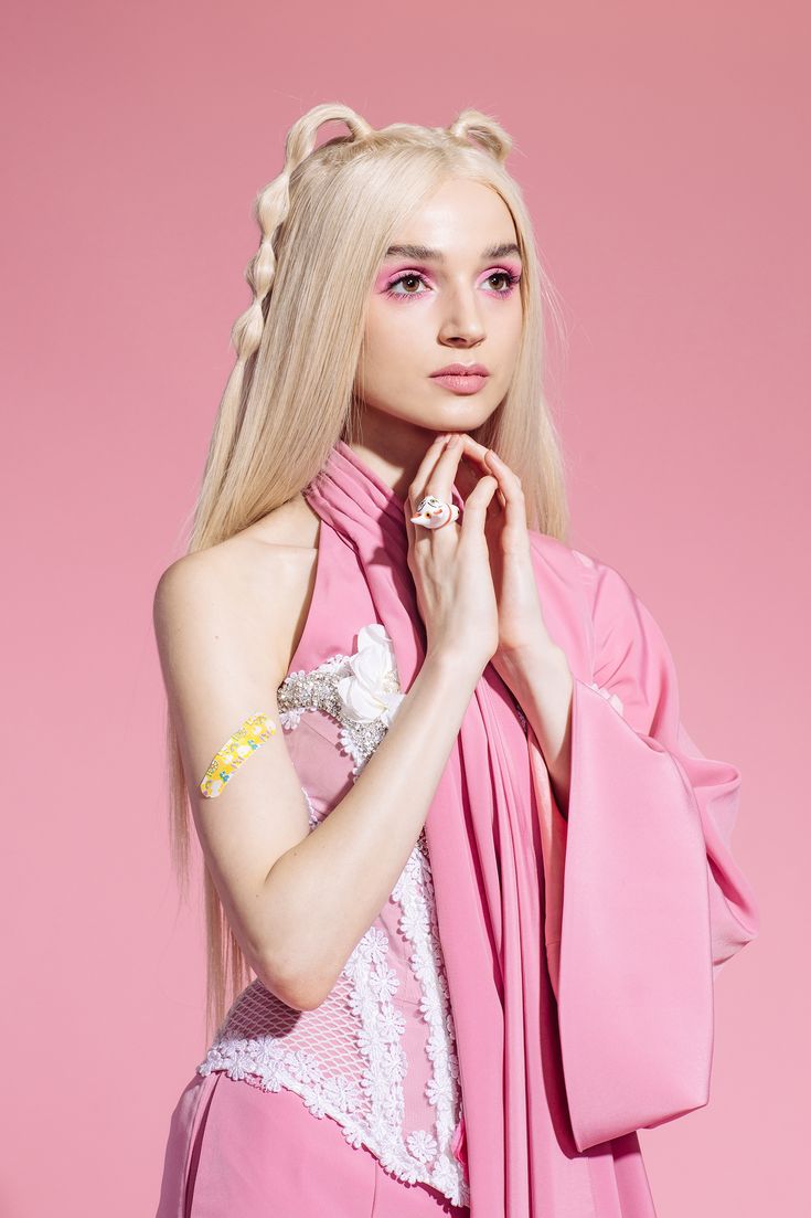 a woman with long blonde hair wearing a pink dress and holding a pink handbag