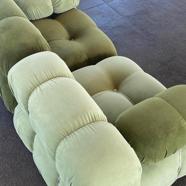 a large green couch sitting on top of a floor