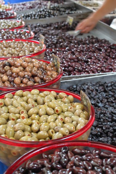 olives and other fruits are on display in bowls