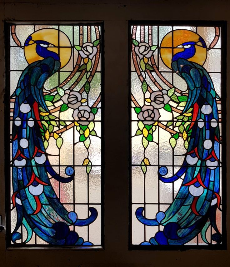 two stained glass windows with peacocks on them