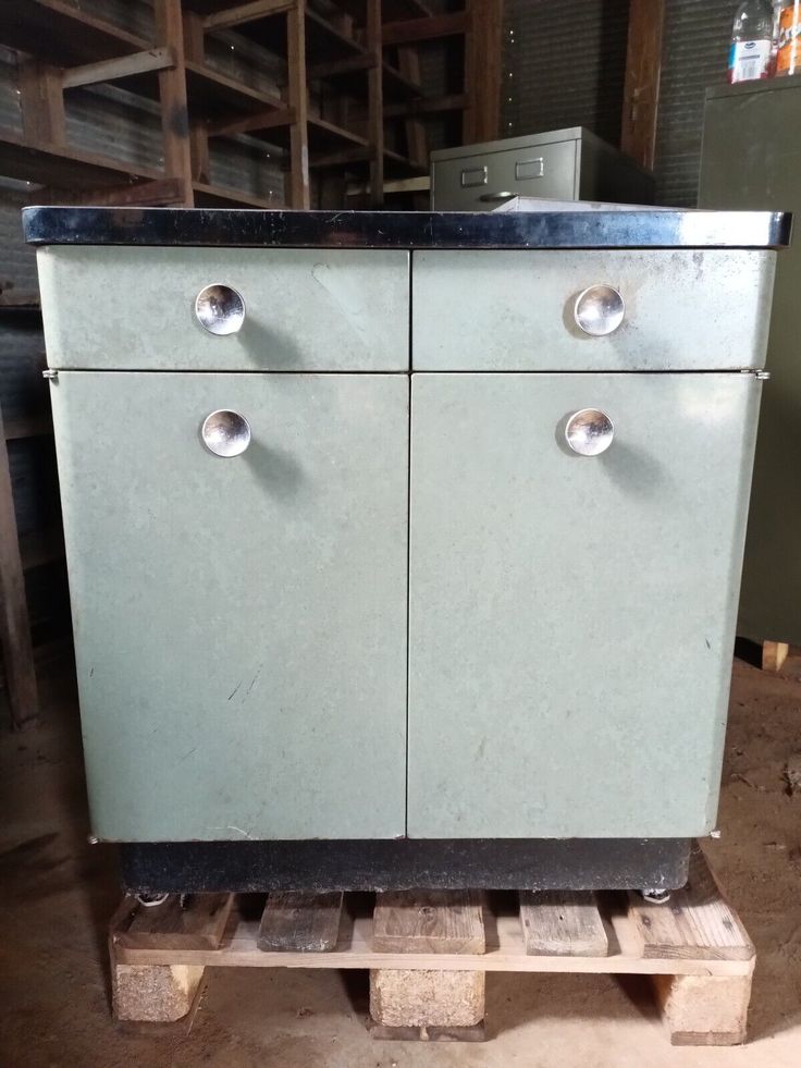 an old metal cabinet sitting on top of a wooden pallet