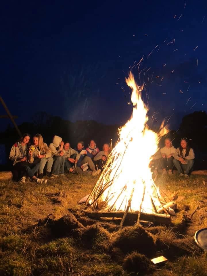 people sitting around a campfire at night