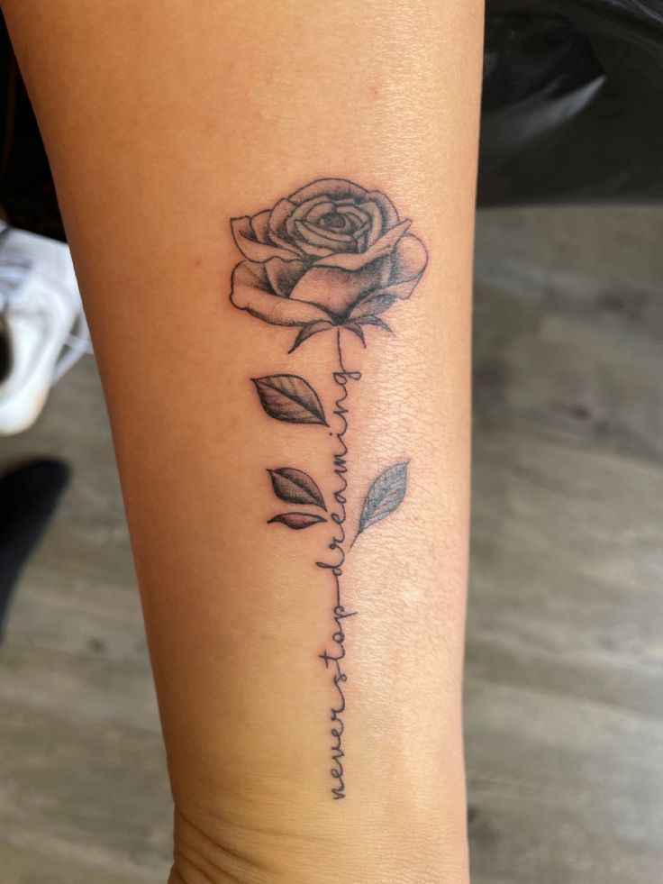 a woman's leg with a rose tattoo on it and the word love written in cursive writing