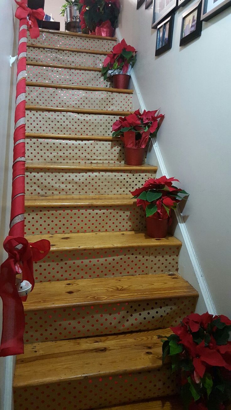 the stairs are decorated with poinsettias and ribbons