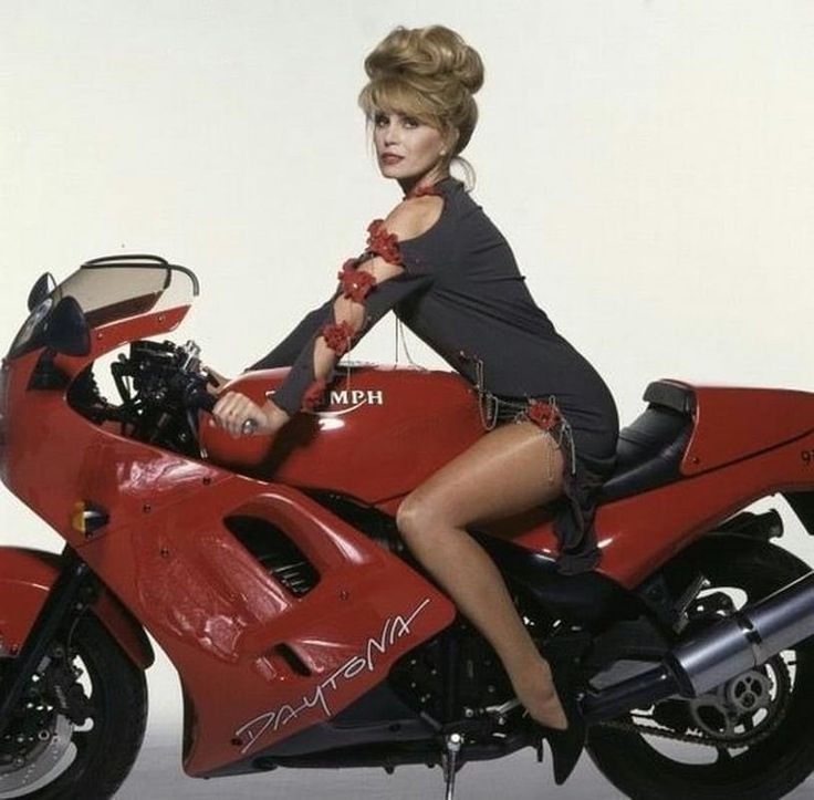 a woman sitting on top of a red motorcycle