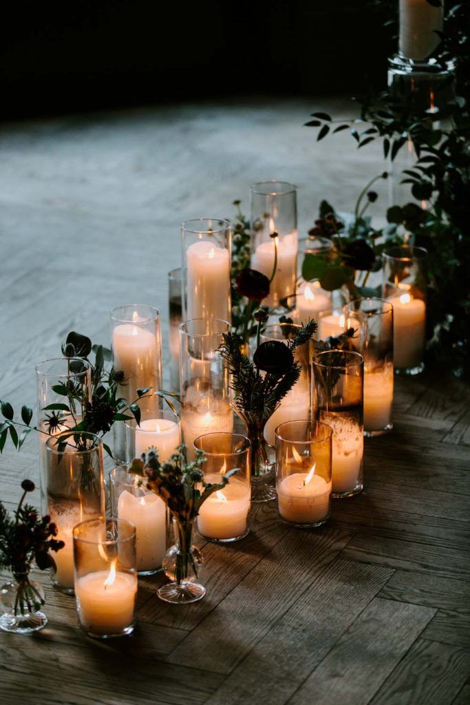 many lit candles are lined up on the floor