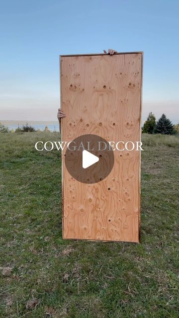 a wooden door sitting on top of a lush green field