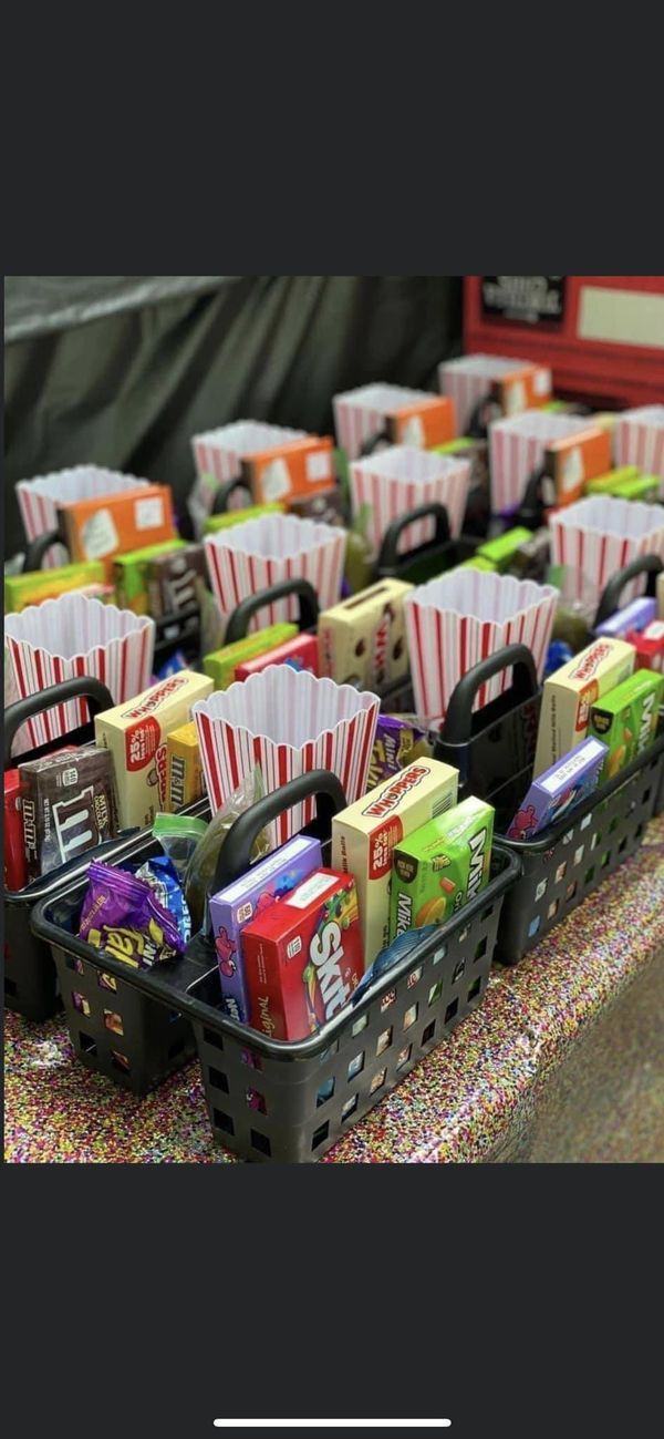 a table topped with baskets filled with boxes and candy bar wrappers on top of it