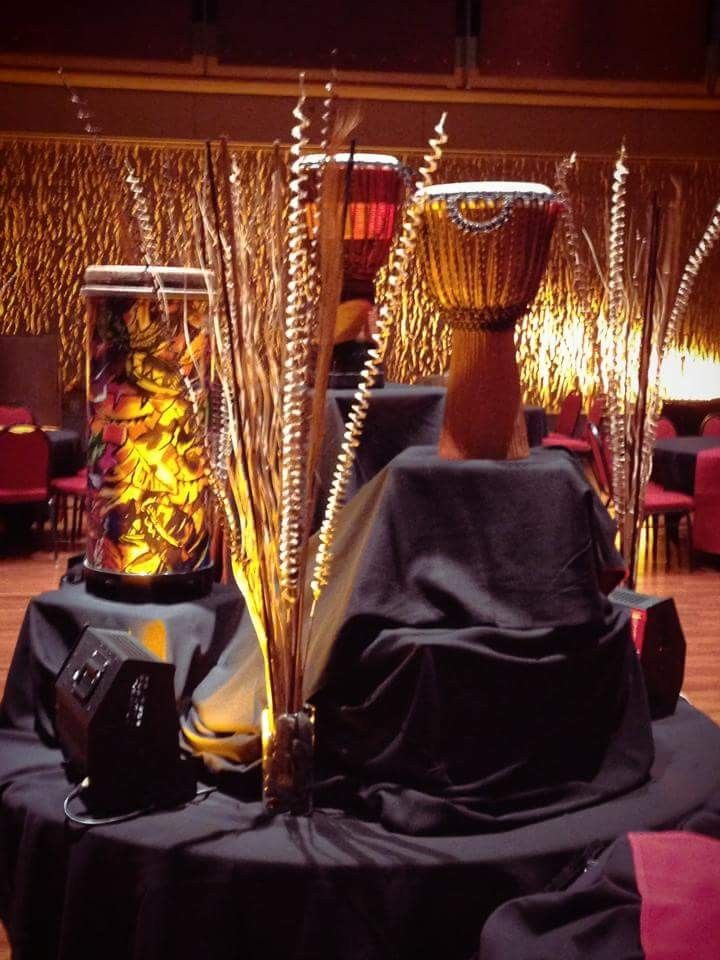 there are two vases on the table with black cloth and gold decorations around it