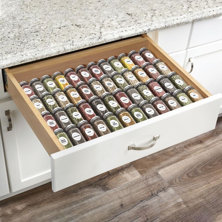 an open drawer in a kitchen filled with spices