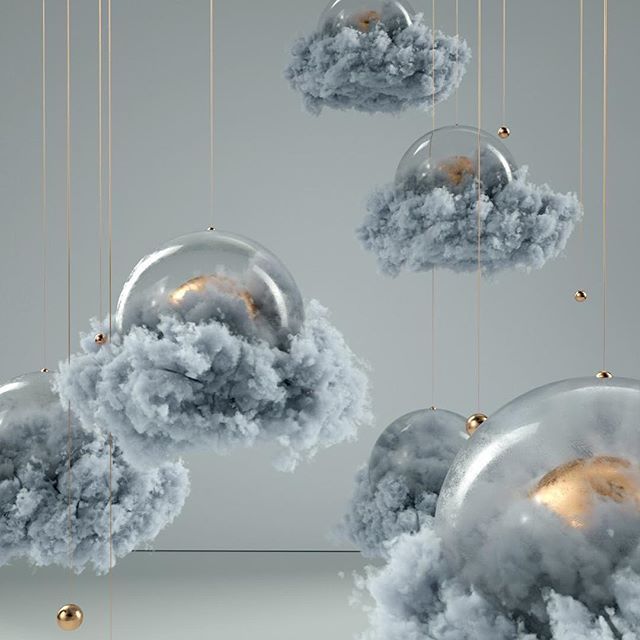 some clouds are floating in the air and hanging from strings with gold balls on them