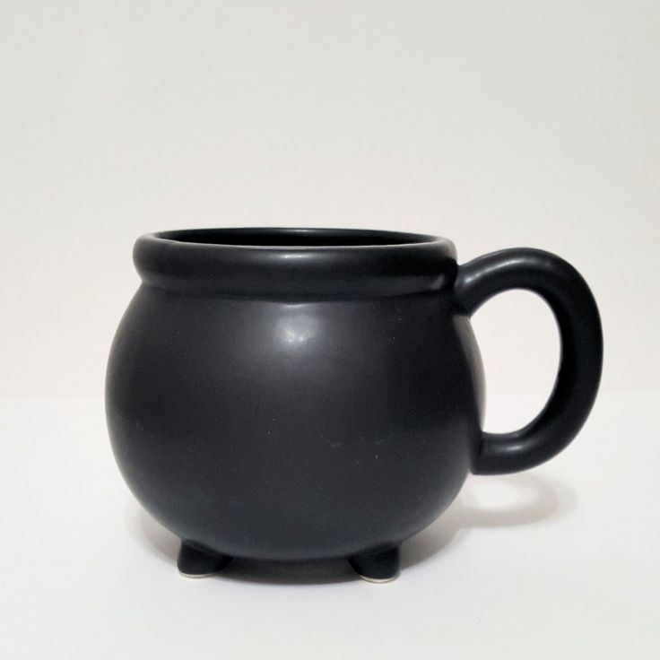 a black mug sitting on top of a white table