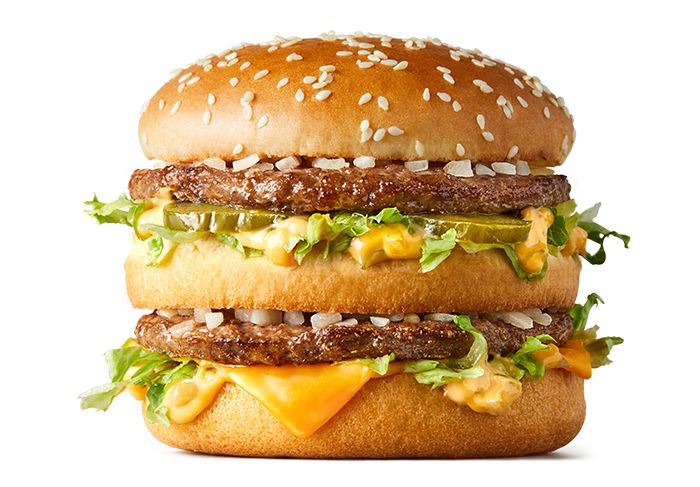 two hamburgers with cheese, lettuce and other toppings are stacked on top of each other